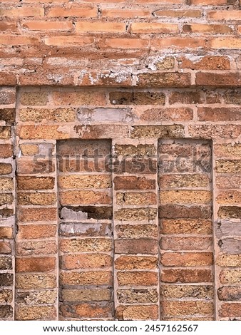 a photography of a brick wall with a fire hydrant in the middle.