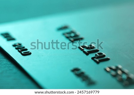 One credit card on turquoise background, macro view Royalty-Free Stock Photo #2457169779