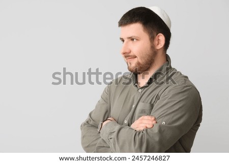 Young Jewish man in hat on light background Royalty-Free Stock Photo #2457246827