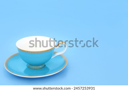 Blue and gold bone china tea cup. Elegant luxury drinking set on pastel blue background with copy space. Minimal zen composition. Royalty-Free Stock Photo #2457253931