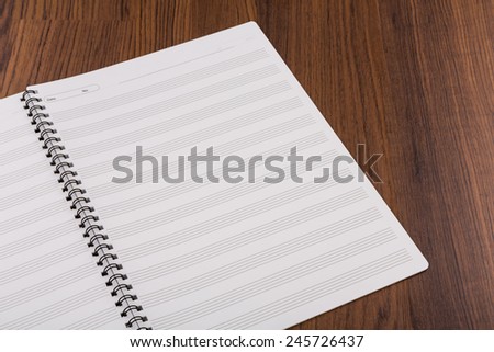 Blank musical notes book mock up on wood background