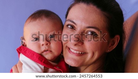 Mother and baby posing for photo together looking to camera