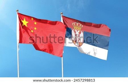 There are Chinese and Serbian flags on the cloudy sky. fly in the sky