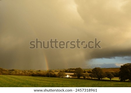Landscape picture of storm cloud and rainbow