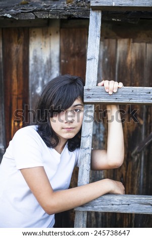 Black-haired teen girl with expressive eyes, a portrait in the countryside. Emo.