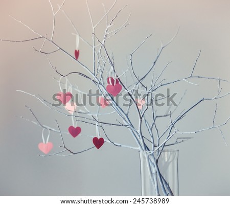 Beautiful decorative white branches with small valentine's hearts. Toned picture