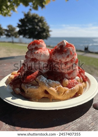 Indulge in the sweet nostalgia of carnival delights with this mouthwatering stock picture of a freshly fried funnel cake.