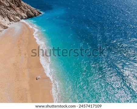 A beautiful view of Kaputaş Beach in Kaş, Kalkan, Antalya, Turkey, highlighting the vibrant turquoise waters and golden sand of this Mediterranean gem. Royalty-Free Stock Photo #2457417109