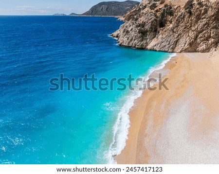An aerial view of Kaputaş Beach, Kalkan, Turkey, showcasing the turquoise waters of the Mediterranean Sea and the scenic coastal town. Royalty-Free Stock Photo #2457417123
