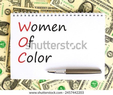 WOC women of color symbol. Concept words WOC women of color on beautiful white note. Dollar bills. Beautiful dollar bills background. Business WOC women of color social issues concept. Copy space. Royalty-Free Stock Photo #2457442203