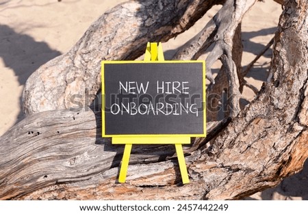 New hire onboarding symbol. Concept words New hire onboarding on beautiful black yellow blackboard. Beautiful tree background. Business new hire onboarding concept. Copy space.
