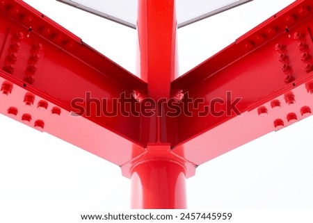 Large screw hexagon flange red nut supporting structures, metal frame of prefabricated building on white background. Large metal posts or structure are painted of outdoor billboard construction work. Royalty-Free Stock Photo #2457445959