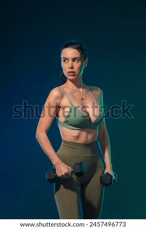 Sporty fit woman, athlete with dumbbells make fitness exercises on neon background. Download cover for music collection for fitness classes. Sports recreation. Beautiful black young woman.
