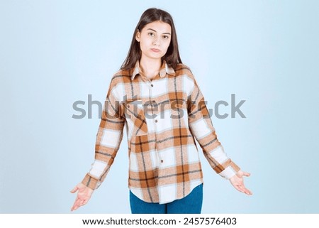 Photo of a young girl model standing on white-gray background. High quality photo