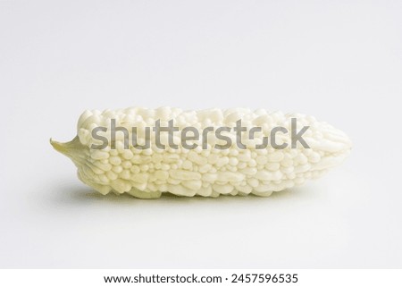 A fresh white bitter melon isolated on a white background. Bitter melon (Momordica charantia) is a tropical and subtropical vine of the family Cucurbitaceae grown for its edible fruit. Royalty-Free Stock Photo #2457596535