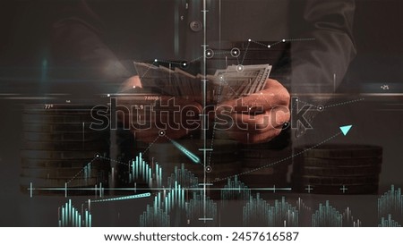 Profitability graphs and coordinate system against the backdrop of hands counting dollar bills and a translucent background of columns of coins. Cg.