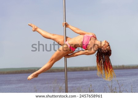 A skinny pole dance girl show her extremely skills with pole outdoor on islands Royalty-Free Stock Photo #2457658961