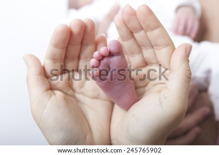 Baby foot cupped into mothers hands.