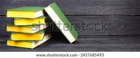 Books on wooden table, black board background. Back to school. Education business concept. panorama, banner