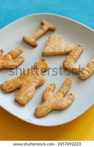 Homemade figure cookies I love you on a blue and yellow background. Baking at home.
