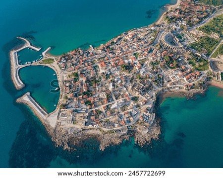 An aerial view of the historic peninsula of Side in Antalya, Turkey. The scene highlights the iconic Apollo Temple, Roman ruins, a charming harbor, and a picturesque townscape. Royalty-Free Stock Photo #2457722699