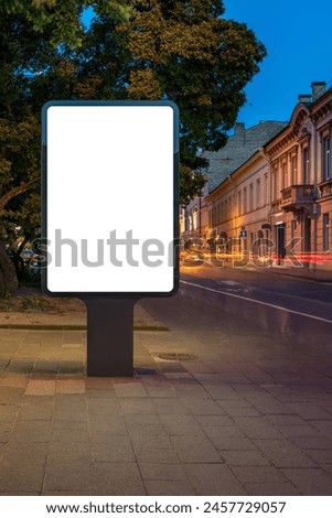 Mockup Of An Outdoor Poster Billboard On Old Town Street At Night. Blank Advertising Display With Car Light Trails In The Background
