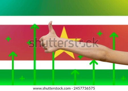 Suriname flag with green up arrows, finger thumbs up front of Suriname flag, country statistics concept, upward rising arrow on data, increasing values and improving economy
