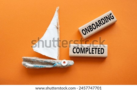 Onboarding Completed symbol. Concept word Onboarding Completed on wooden blocks. Beautiful orange background with boat. Business and Onboarding Completed concept. Copy space