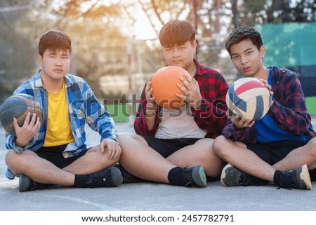 Asian boys in plaid shirt spending their free times together at outdoor basketball court, soft focus, concept for freestyle and lifestyle of young teens around the world.