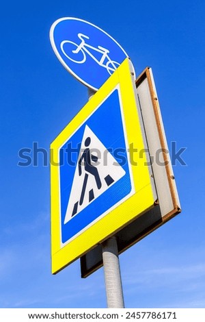 Bicycle road sign for bikes lane and pedestrian crossing sign against the blue sky background