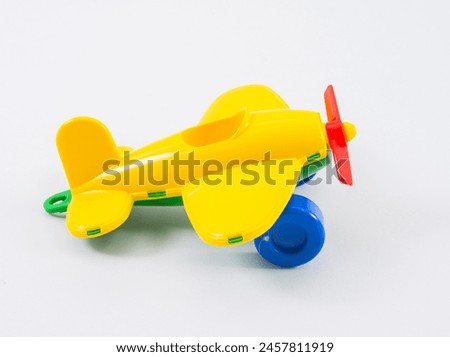 Children's plastic multi-colored airplane on a white background.
