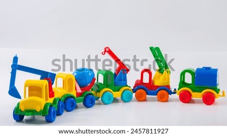 Plastic toy multi-colored truck on a white background. Construction equipment group.