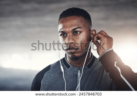 Fitness, earphones and man with thinking for workout, exercise planning or cardio for wellness. Male person, idea and serious with headphones for audio, music streaming or training podcast in morning
