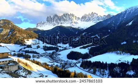 The snow-covered mountains, with a cozy cabin in the foreground, create a serene and picturesque scene. Royalty-Free Stock Photo #2457865103