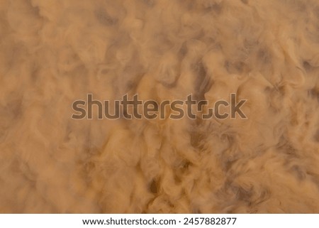 Brown dirty water. The surface of the water is in swirls and clouds of turbidity. Royalty-Free Stock Photo #2457882877
