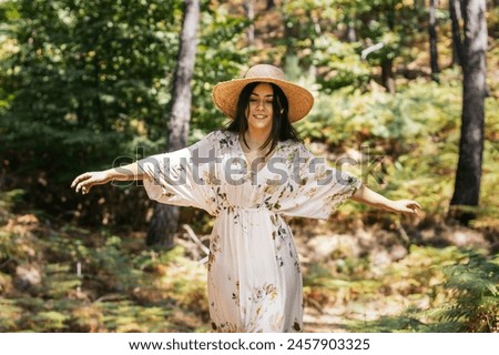 Woman enjoying a day in nature, walking through the forest