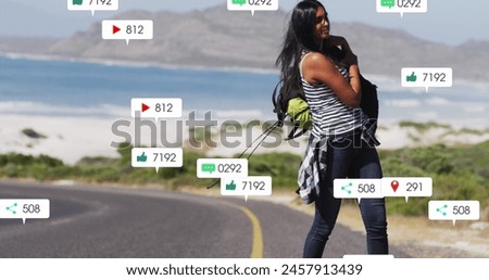 Image of notification bars over biracial woman picking up bag from road. Digital composite, multiple exposure, business, growth, adventure, social media reminder and technology concept.