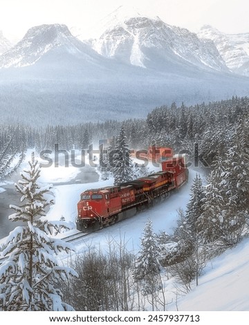 Beautiful scenic viewpoint of "Morant's Curve", near Lake Louise in Canada in winter time. Train is passing through the Canadian Rockies. It is a popular photographer location in Canada. Royalty-Free Stock Photo #2457937713