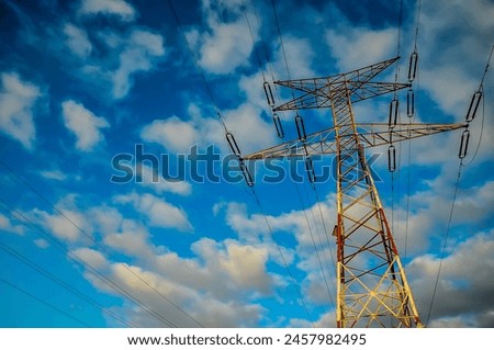 A tall power tower is visible in the sky above a blue sky. The clouds are scattered throughout the sky, giving the scene a somewhat moody atmosphere, real image