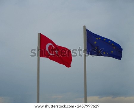 blue with golden stars euro union flag , red turkish with moon  against blue sky, Ankara, Brussels, Bruxelles