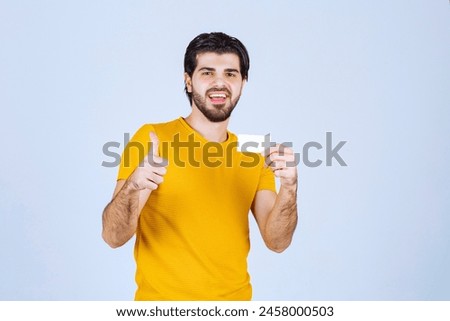 Man holding a business card and showing enjoyment sign. High quality photo