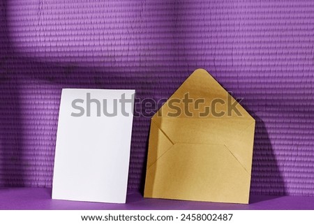 Blank greeting card, flyer or invitation card mockup and brown envelope with shadow, Valentines or women's day heart near purple wall