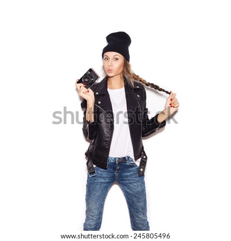 Pretty woman in black beanie having fun with vintage noname camera. White background, not isolated