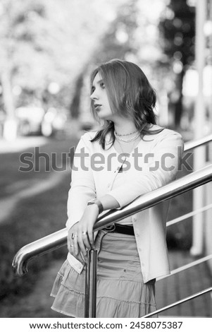 Portrait of a young beautiful red-haired girl outdoors. Black and white photo.
