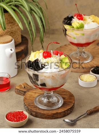 Es campur (Indonesian for "mixed ice") is an Indonesian cold and sweet dessert concoction of fruit cocktails, coconut, tapioca pearls, grass jellies, etc. Royalty-Free Stock Photo #2458075559