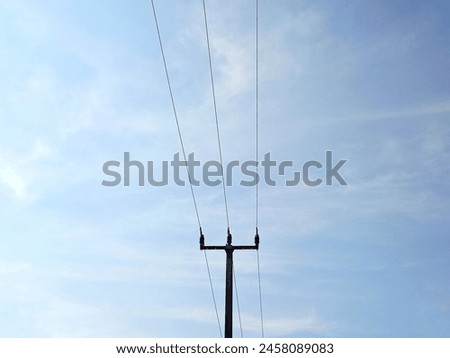Photo of electricity poles against a blue sky background