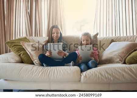 Girl, children and tablet on couch for online streaming, social media and happy together on holiday in home. Family, sister and technology on sofa for internet, gaming and smile for cartoon in lounge