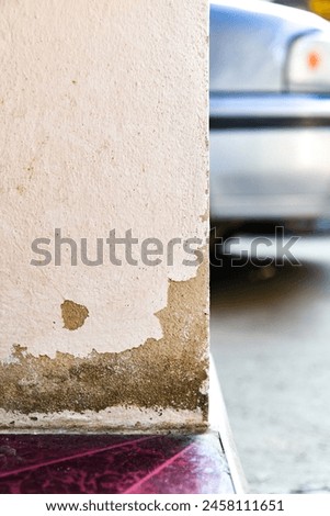 The white cement pillars have paint peeling off over time. Royalty-Free Stock Photo #2458111651