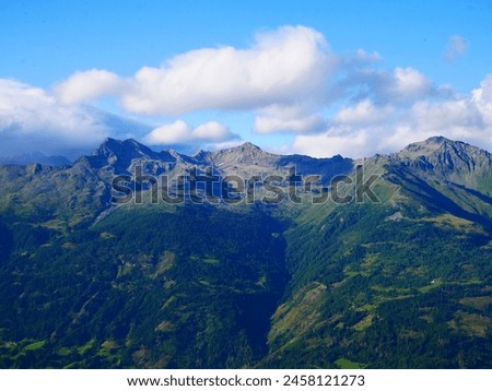 View on mountains in the Osttirol region on a summer day,mountains, sky, clouds. Lush green vegetation.  Alps, Austria.  Royalty-Free Stock Photo #2458121273