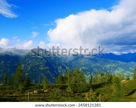 View on mountains in the Osttirol region on a summer day,mountains, sky, clouds. Lush green vegetation.  Alps, Austria.  Royalty-Free Stock Photo #2458121281